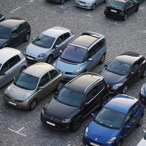 Das Bild zeigt einen Parkplatz mit mehreren geparkten Autos.