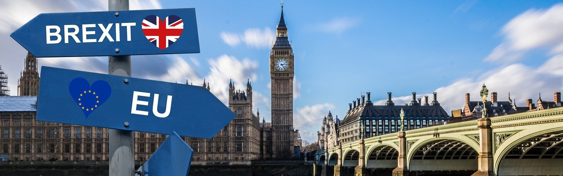 Das Bild zeigt das Parlamentsgebäude mit dem Big Ben in London. Im Vordergrund sieht man zwei Schilder mit den Aufschriften EU und Brexit. Beide zeigen in unterschiedliche Richtungen.