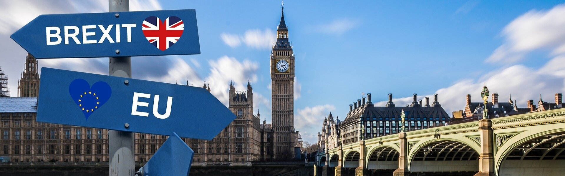 Das Bild zeigt das Parlamentsgebäude mit dem Big Ben in London. Im Vordergrund sieht man zwei Schilder mit den Aufschriften EU und Brexit. Beide zeigen in unterschiedliche Richtungen.