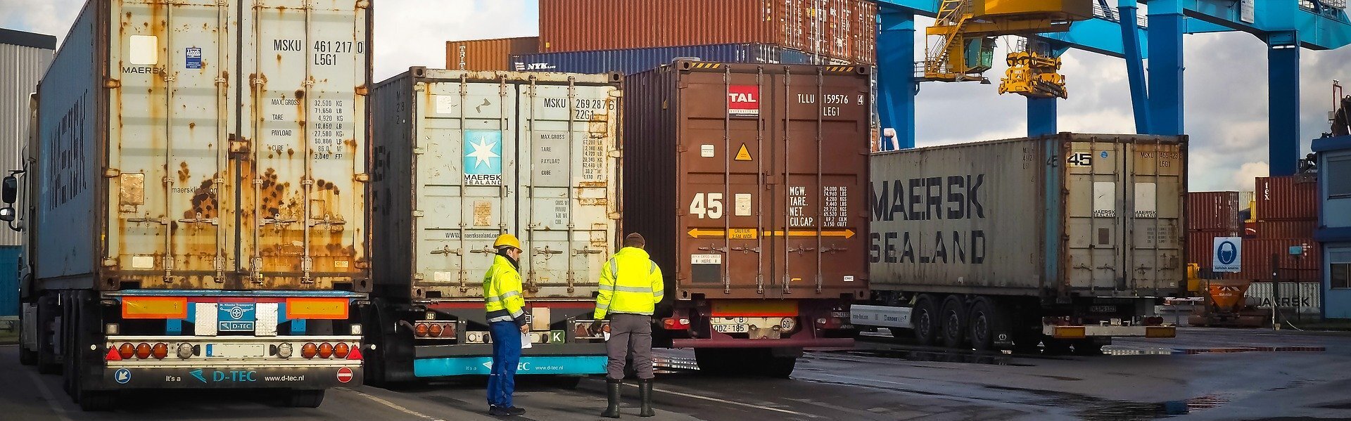 Das Bild zeigt mehrere Container auf LKWs.