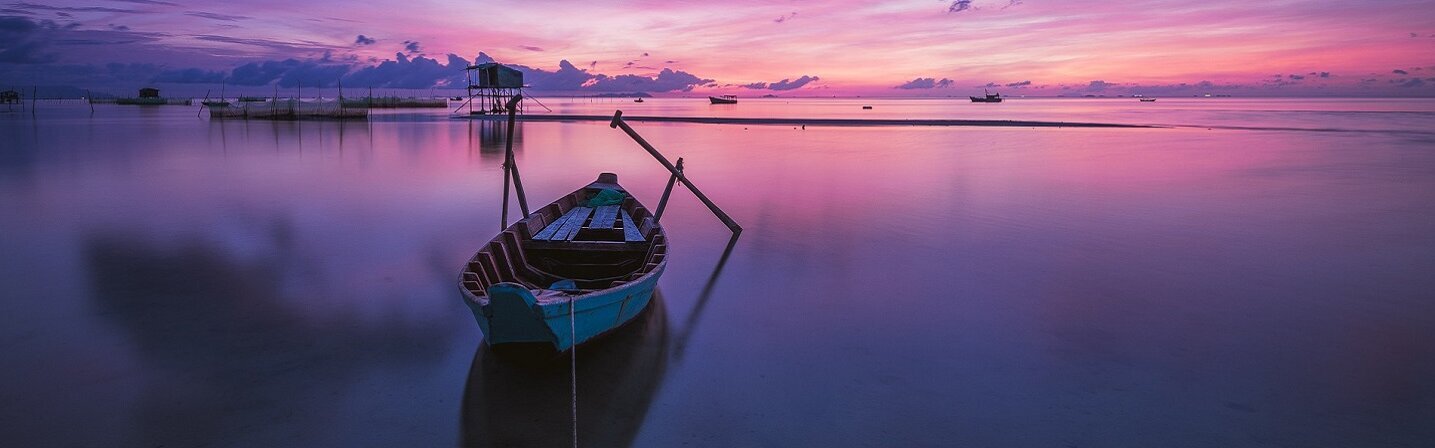 Das Bild zeigt einen Sonnenaufgang in Vietnam mit Boot.