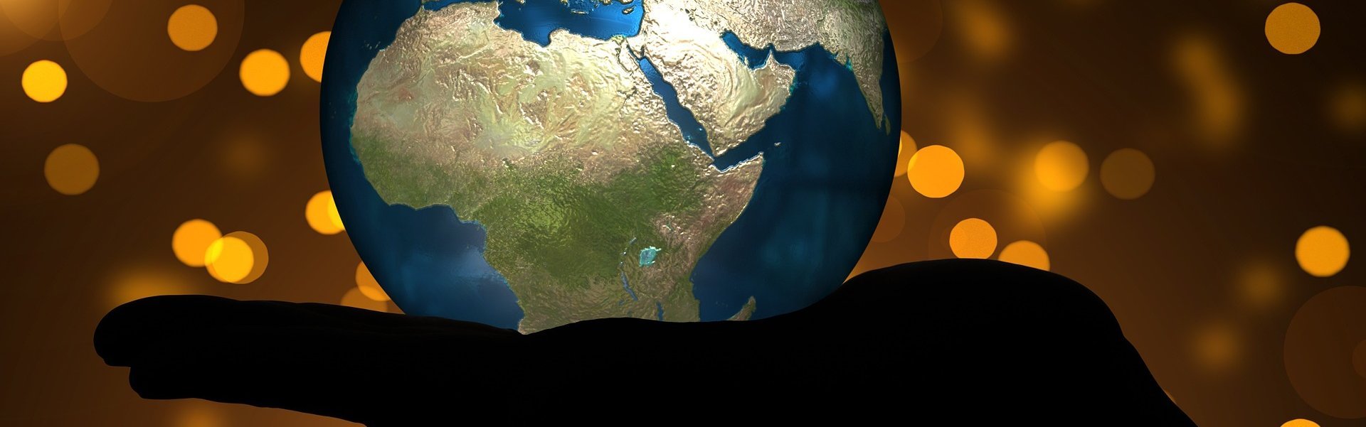 Das Bild zeigt eine Weltkugel, die auf einer Hand liegt. Der afrikanische Kontinent zeigt nach vorn.