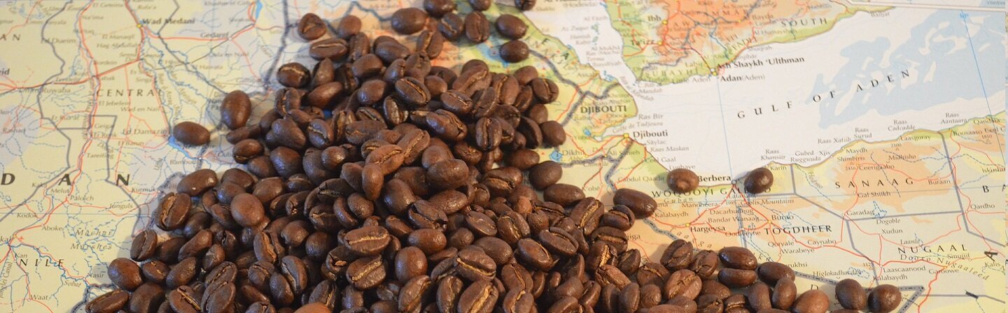 Das Bild zeigt Kaffeebohnen auf einer Landkarte.